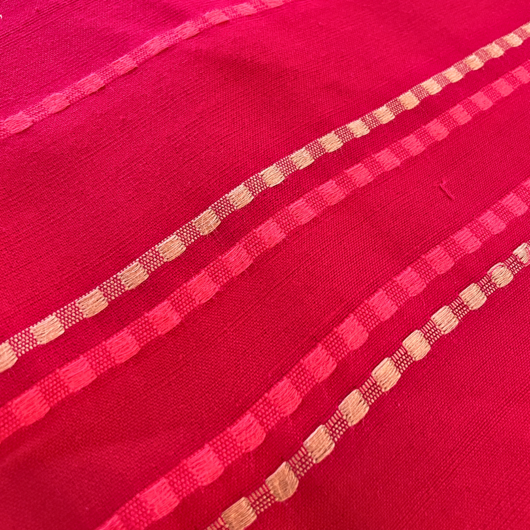 Pink scarf with orange and white stripes and fringes on a gray background