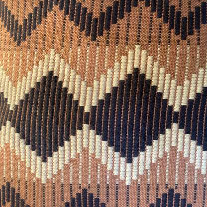 Close-up of a patterned fabric with zigzag design in brown, black, and white.